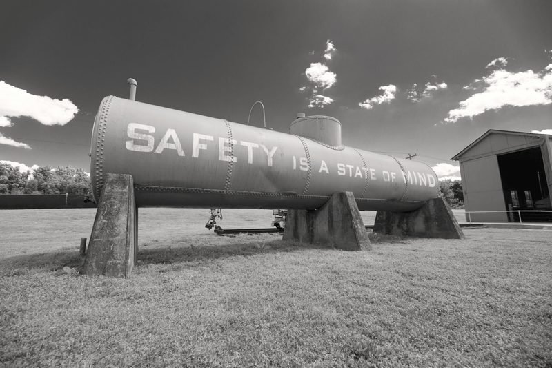 A large horizontal storage tank on concrete saddles, in black and white